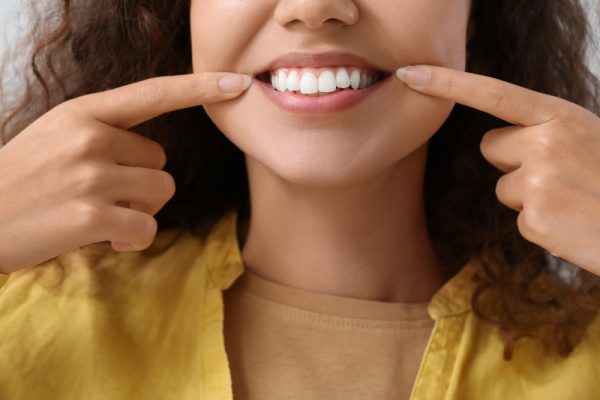 woman pointing at her smile