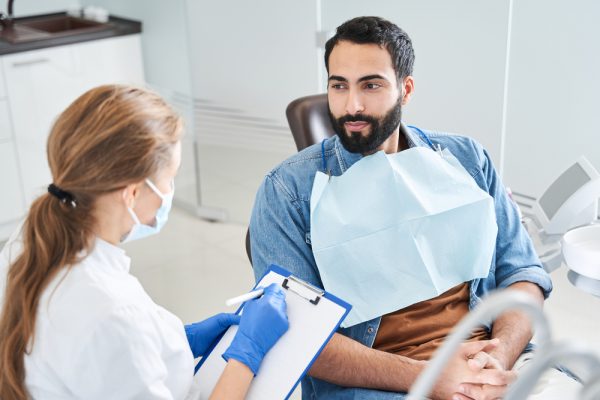 dentist speaking to patient in dental chair